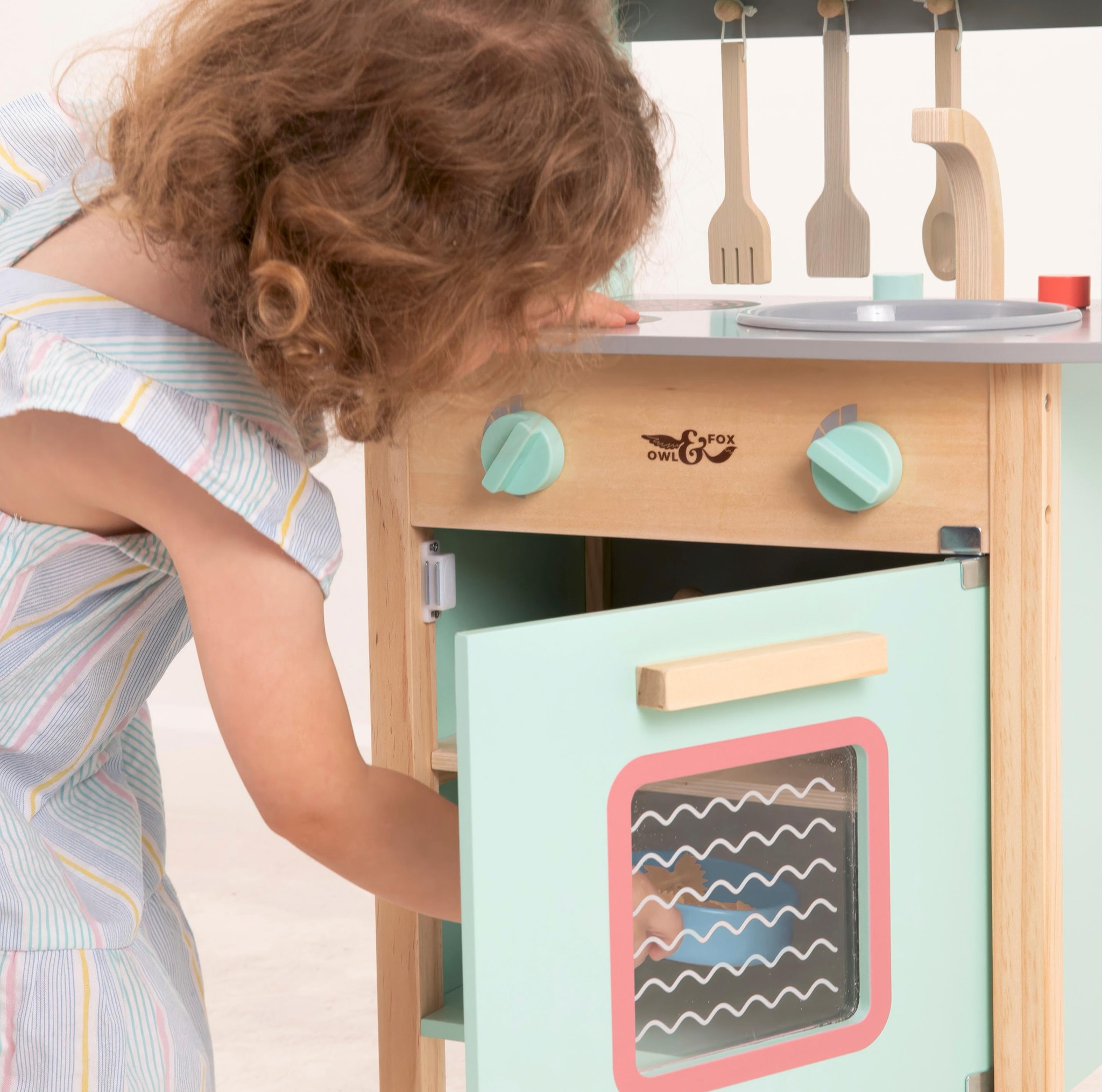 Child playing with a toy kitchen